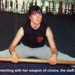 Lucy practices stretching with her weapon of choice, the staff.