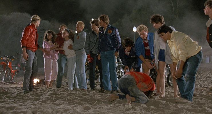 Cobra Kai students bullying Daniel and Ali at the beach.